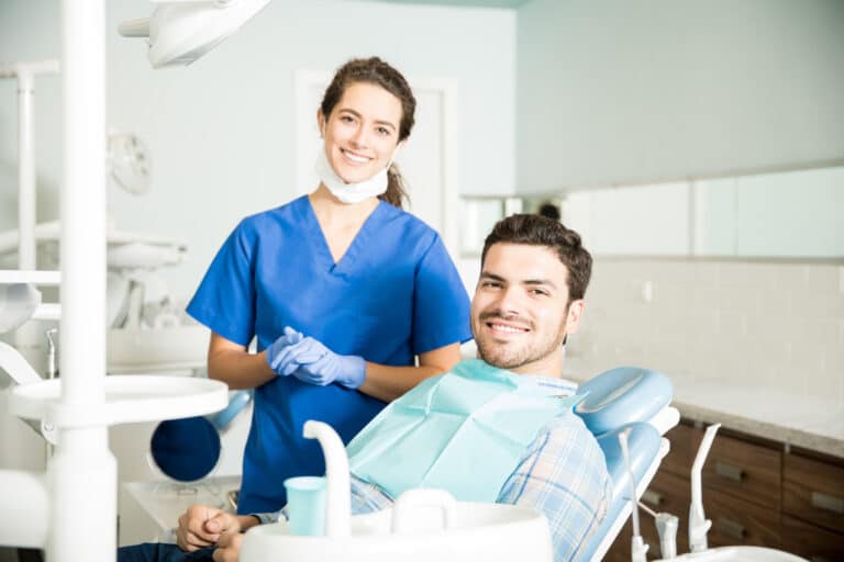 Portrait,Of,Smiling,Young,Female,Dentist,Standing,By,Mid,Adult