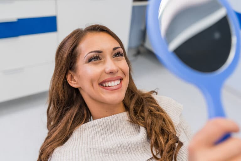 Happy,Woman,Patient,Looking,In,The,Mirror,At,The,Teeth,