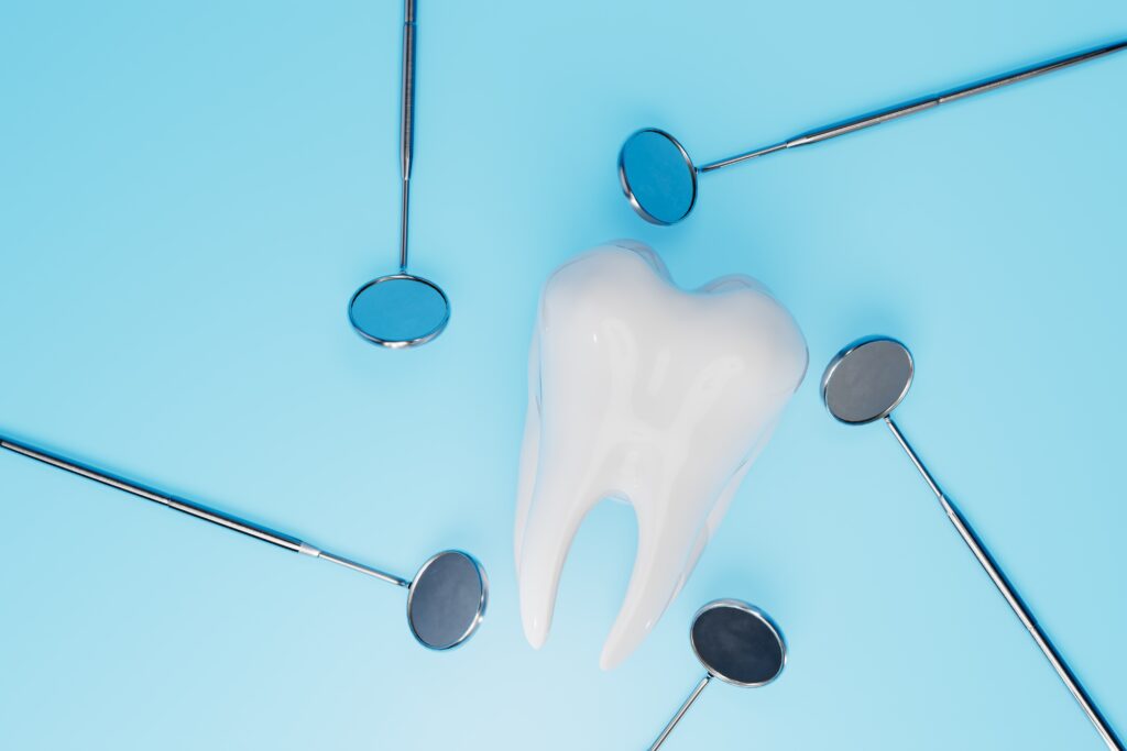 Picture of a tooth figurine surrounded by five dental mirrors.