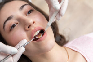 Picture of a woman receiving dental treatment for the white spots on her teeth.